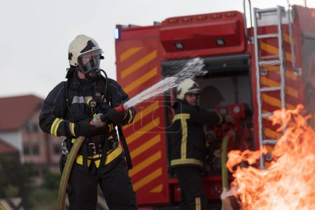 Foto de Bomberos que usan extintor de niebla de agua para luchar con la llama de fuego para controlar el fuego y no extenderse. Concepto de bombero industrial y de seguridad pública. Foto de alta calidad - Imagen libre de derechos