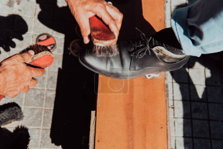 Photo for An old man hand polishing and painting a black shoe at street. - Royalty Free Image