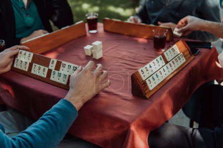 A group of men drink traditional Turkish tea and play a Turkish game called Okey. 
