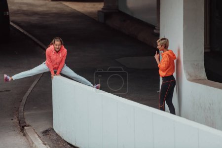 Téléchargez les photos : Deux femmes en tenue de sport qui courent dans un environnement urbain moderne. Le concept d'un mode de vie sportif et sain. - en image libre de droit