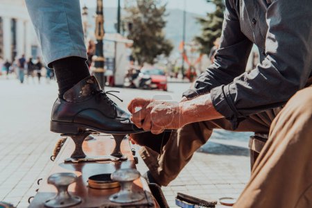 Photo for An old man hand polishing and painting a black shoe at street. - Royalty Free Image
