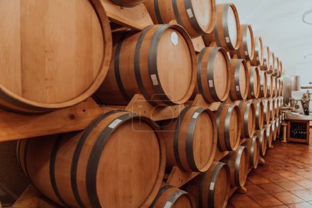 Téléchargez les photos : Barils de vin ou de cognac dans la cave de la cave, Barils de vin en bois en perspective. Voûtes à vin.Fûts de chêne vintage de bière artisanale ou de brandy. - en image libre de droit