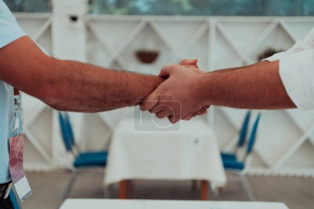 Photo for Close up a handshake, businessman together creates a mutually beneficial business relationship. The economic graph on the table. - Royalty Free Image
