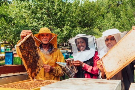 Photo for Arab investors checking the quality of honey on a large bee farm in which they have invested their money. The concept of investing in small businesses. - Royalty Free Image