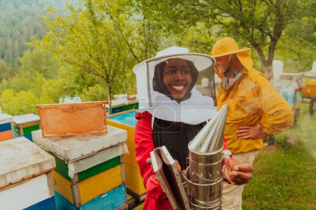 Téléchargez les photos : Investisseur arabe avec un apiculteur expérimenté contrôlant la qualité et la production de miel dans une grande ferme apicole. - en image libre de droit