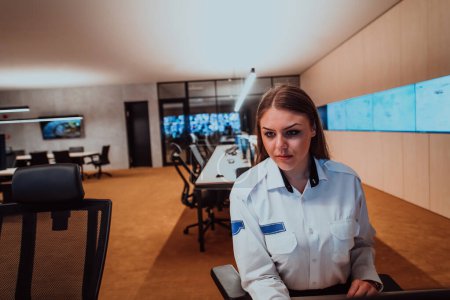 Téléchargez les photos : Opérateur de sécurité féminin travaillant dans une salle de contrôle du système de données Opérateur technique Travaillant au poste de travail avec plusieurs écrans, agent de sécurité travaillant sur plusieurs moniteurs. - en image libre de droit