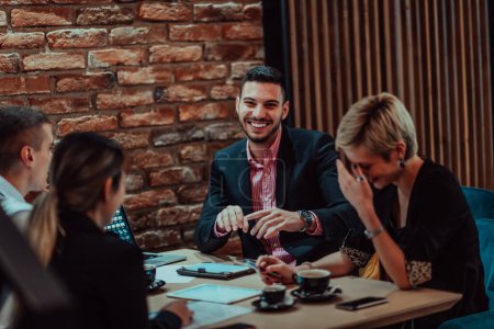 Téléchargez les photos : Heureux gens d'affaires souriant joyeusement lors d'une réunion dans un café. Groupe de professionnels d'entreprise prospères travaillant en équipe dans un milieu de travail multiculturel. - en image libre de droit