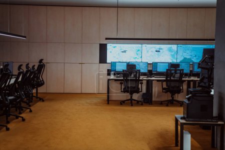 Photo for Empty interior of big modern security system control room, workstation with multiple displays, monitoring room with at security data center Empty office, desk, and chairs at a main CCTV security data - Royalty Free Image