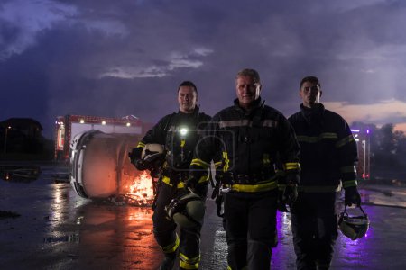 Téléchargez les photos : Équipe de pompiers courageux Marcher après avoir terminé. L'équipe paramédicale et de secours des pompiers lutte contre l'incendie dans les accidents de la route, l'assurance et sauve des vies concept - en image libre de droit