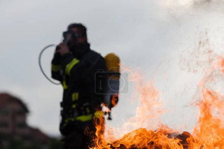 Foto de Retrato de un bombero heroico con traje protector. Bombero en operación de extinción de incendios - Imagen libre de derechos