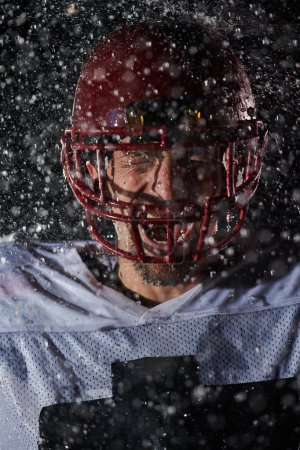 Photo for American Football Field: Lonely Athlete Warrior Standing on a Field Holds his Helmet and Ready to Play. Player Preparing to Run, Attack and Score Touchdown. Rainy Night with Dramatic Fog, Blue Light. - Royalty Free Image