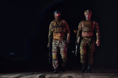 Foto de Dos soldados profesionales marchando a través de la oscuridad de la noche en una misión peligrosa, personificando su valentía inquebrantable, el trabajo en equipo inquebrantable, y la intensidad de alto riesgo de su especializado - Imagen libre de derechos
