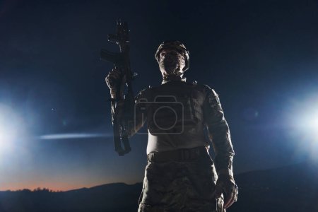 Téléchargez les photos : Un soldat professionnel en équipement militaire complet traversant la nuit noire alors qu'il entreprend une mission militaire périlleuse. - en image libre de droit