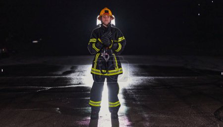 Foto de Retrato de una bombera de pie y caminando valiente y optimista. - Imagen libre de derechos