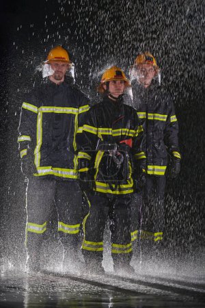 Photo for A group of professional firefighters marching through the rainy night on a rescue mission, their determined strides and fearless expressions reflecting their unwavering bravery and unwavering - Royalty Free Image