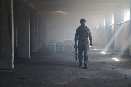 Téléchargez les photos : Un soldat professionnel dans un bâtiment abandonné fait preuve de courage et de détermination dans une campagne de guerre. - en image libre de droit