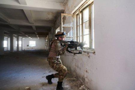 Téléchargez les photos : Un soldat professionnel accomplit une mission militaire dangereuse dans un bâtiment abandonné. - en image libre de droit