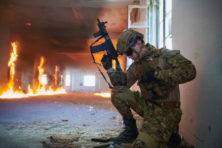 Téléchargez les photos : Soldat en action près de fenêtre changeant de magazine et prendre refuge. - en image libre de droit