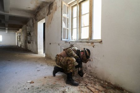 Foto de Un soldado profesional realiza una peligrosa misión militar en un edificio abandonado. - Imagen libre de derechos