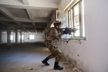 Téléchargez les photos : Un soldat professionnel accomplit une mission militaire dangereuse dans un bâtiment abandonné. - en image libre de droit