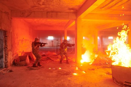 Téléchargez les photos : Un groupe de soldats professionnels exécute courageusement une mission de sauvetage dangereuse, entourée d'un incendie dans un bâtiment périlleux - en image libre de droit