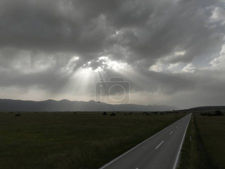 Téléchargez les photos : Vue aérienne d'une route de campagne vide dans une belle nature de prairie pendant une journée nuageuse d'été. - en image libre de droit
