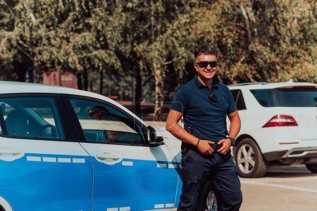 Photo for A policeofficer patrols the city. A police officer with sunglasses patroling in the city with an official police car. - Royalty Free Image