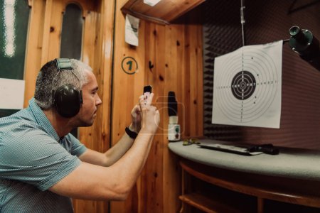 Photo for A man in a shooting range takes a picture and examines the results after shooting. High quality photo - Royalty Free Image