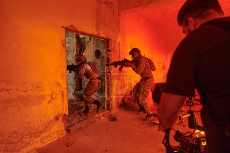 Foto de Un camarógrafo profesional captura los momentos intensos cuando un grupo de soldados expertos se embarca en una peligrosa misión dentro de un edificio abandonado, sus acciones llenas de suspenso y valentía.. - Imagen libre de derechos