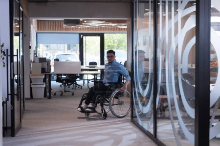 Téléchargez les photos : Dans une grande société moderne, un homme d'affaires déterminé dans un fauteuil roulant navigue dans un couloir, incarnant l'autonomisation et l'inclusion dans le monde des entreprises - en image libre de droit