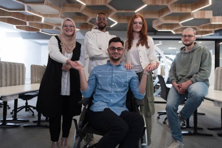 Foto de Jóvenes empresarios en una oficina moderna extienden un apretón de manos a su colega de negocios en silla de ruedas, mostrando inclusividad, apoyo y unidad en el entorno corporativo - Imagen libre de derechos