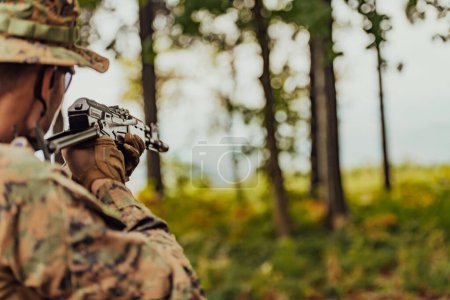Foto de Un soldado de guerra moderno en servicio de guerra en zonas boscosas densas y peligrosas. Operaciones peligrosas de rescate militar. - Imagen libre de derechos