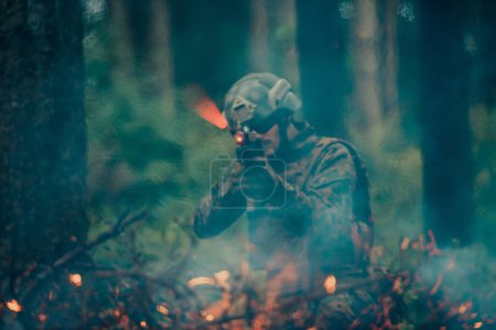 Foto de Un soldado lucha en una zona de bosque rodeado de fuego. - Imagen libre de derechos