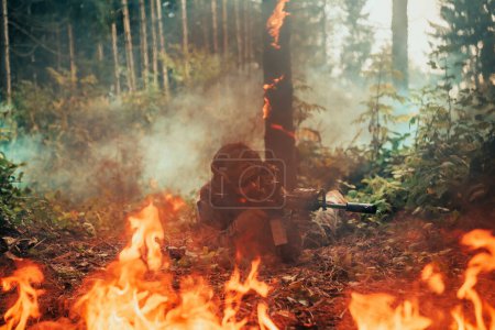 Foto de Soldado de guerra moderno rodeado de fuego, lucha en zonas boscosas densas y peligrosas. - Imagen libre de derechos