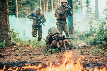 Photo for Modern warfare soldiers surrounded by fire fight in dense and dangerous forest areas. - Royalty Free Image