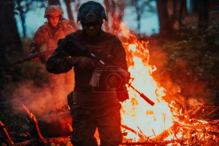 Photo for Soldier in Action at Night in the Forest Area. Night Time Military Mission jumping over fire. - Royalty Free Image
