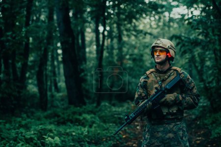 Photo for A modern warfare soldier on war duty in dense and dangerous forest areas. Dangerous military rescue operations. - Royalty Free Image