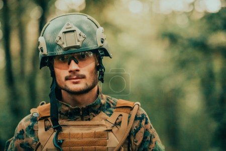 Photo for Soldier portrait with protective army tactical gear and weapon having a break and relaxing. - Royalty Free Image