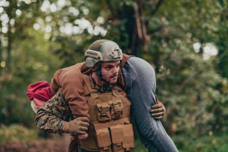 Téléchargez les photos : Soldat secourir une femme civile au combat et apporter aide et assistance médicale. - en image libre de droit