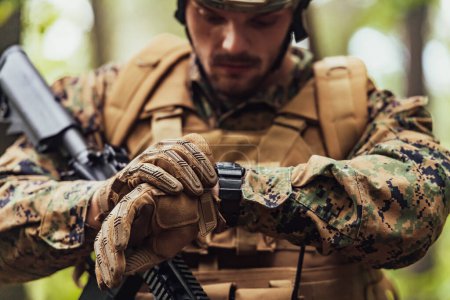 Téléchargez les photos : Corps de marine américain soldat des opérations spéciales préparant matériel tactique et de communication pour l'action bataille gros plan. - en image libre de droit