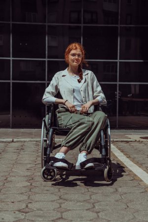 Téléchargez les photos : Devant un bâtiment d'entreprise moderne, une jeune femme assise dans un fauteuil roulant en toute confiance, symbolisant l'autonomisation, l'inclusion et la force de surmonter les défis dans le monde des affaires. - en image libre de droit
