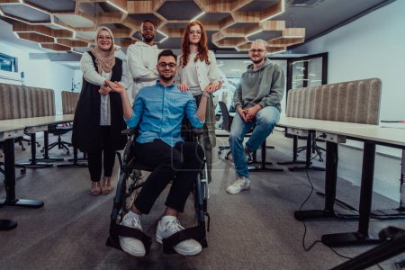 Téléchargez les photos : De jeunes hommes d'affaires dans un bureau moderne serrent la main à leur collègue d'affaires en fauteuil roulant, faisant preuve d'inclusivité, de soutien et d'unité dans l'environnement de l'entreprise. - en image libre de droit