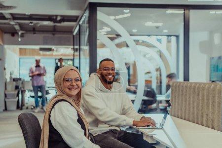 Photo for In a modern office setting, an African American businessman and his Muslim colleague, wearing a hijab, engage in collaborative discussions, tackling various business tasks and solving problems - Royalty Free Image