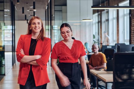 Photo for Group of determined businesswomen confidently pose side by side in a modern startup coworking center, embodying professionalism and empowerment. - Royalty Free Image