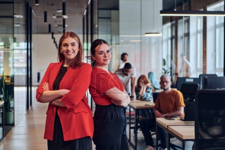 Téléchargez les photos : Groupe de femmes d'affaires déterminées posent en toute confiance côte à côte dans un centre de coworking startup moderne, incarnant le professionnalisme et l'autonomisation. - en image libre de droit