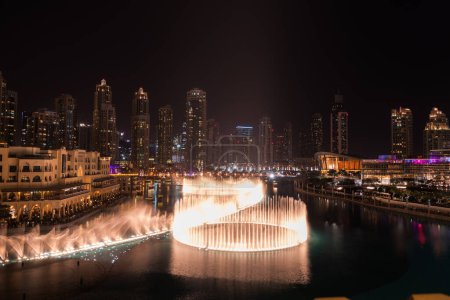 Foto de Vista única del espectáculo de Dubai Dancing Fountain por la noche. Atracción turística. Destino de viaje de lujo en el encantador y hermoso Oriente Medio. - Imagen libre de derechos