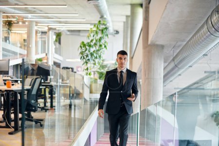 Photo for In a sleek corporate setting, the young and charismatic director strides confidently down the hallway, symbolizing his dynamic leadership and the promise of continued success within the company he - Royalty Free Image