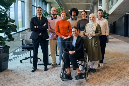 Photo for In a spacious and modern startup office, a diverse group of business colleagues, including a colleague in a wheelchair, collaborates and interacts, exemplifying inclusivity, diversity, and teamwork in - Royalty Free Image