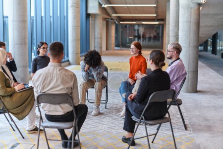 Photo for A diverse group of young business entrepreneurs gathered in a circle for a meeting, discussing corporate challenges and innovative solutions within the modern confines of a large corporation. - Royalty Free Image
