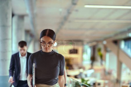 Photo for In the modern corporate world, a diverse group of businesspeople, representing various backgrounds and cultures, briskly walks through the hallway of a cutting-edge startup office, exemplifying - Royalty Free Image
